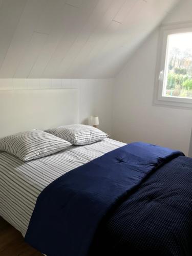 un lit dans une chambre blanche avec une fenêtre dans l'établissement Ejoki, à Sarlat-la-Canéda