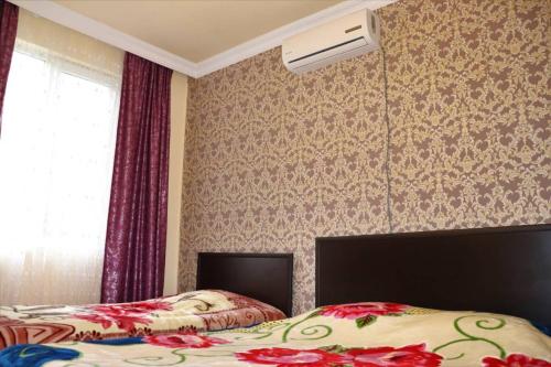 a bedroom with two beds and a window and a fan at Gulnazi Andria in Sarpi