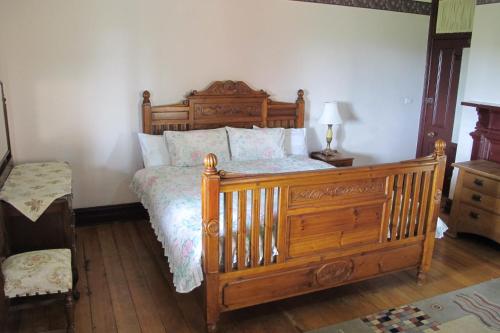 巴瑟斯特的住宿－Holmhurst Guest House，一间卧室配有一张木床和木架