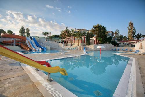 a swimming pool with a slide in a resort at Rethymno Mare Royal & Water Park in Skaleta