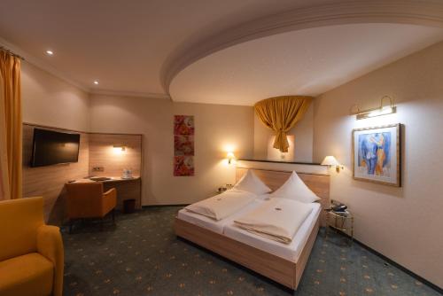 Habitación de hotel con cama y escritorio en Hotel am Schloss, en Illertissen