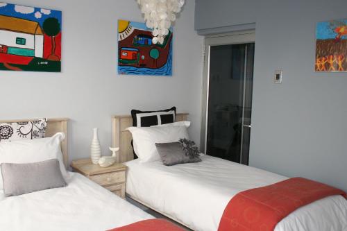 una camera con due letti e un dipinto sul muro di Wild Artz a Città del Capo