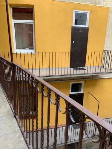 un balcone di un edificio giallo con una porta nera di 5Kotliarska Moisha House a Lviv