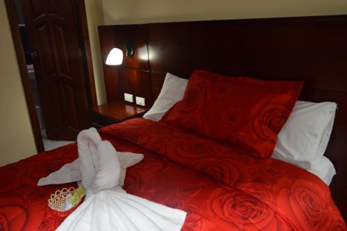 a bedroom with a bed with two towels on it at Balcones del Río Hotel in Latacunga