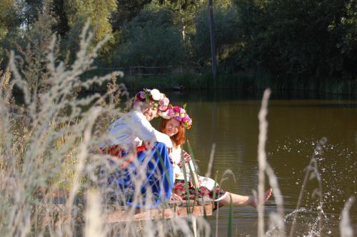 a bride and groom on a boat in the water at Koryakivskyi Rai in Dmitrenki