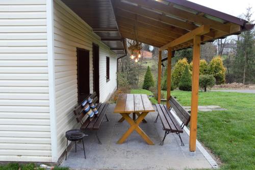 a patio with two benches and a wooden table at U Jędrusia in Polańczyk