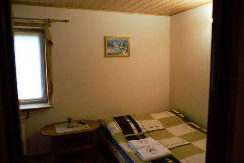 a small room with a bed and a table at U Jędrusia in Polańczyk