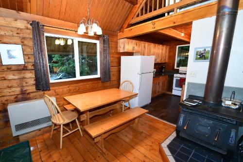 uma cozinha e sala de jantar com uma mesa e um fogão em Alyeska Cabin em Girdwood