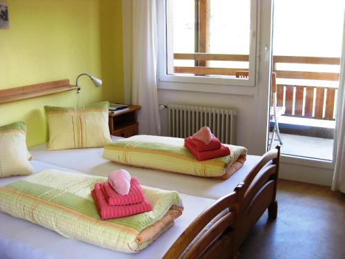 two beds in a bedroom with towels on them at Hotel Bellavista Ftan in Ftan