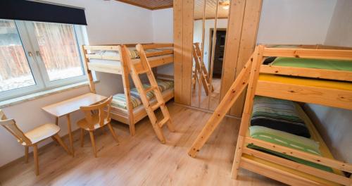 a room with bunk beds and a table and chairs at Haus Binder in Weissensee