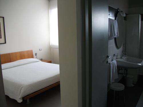 - une petite chambre avec un lit et un lavabo dans l'établissement Vista Hotel & Residence, à Mantoue