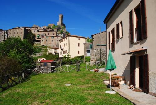 a yard with a green umbrella in front of a building at CASADILUPPE in Roccatederighi