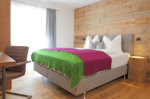 a bedroom with a large bed with a wooden wall at Appartementhaus Reiter Village Room in Altenmarkt im Pongau