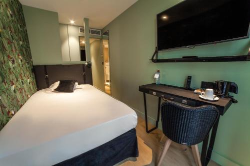 a bedroom with a bed and a desk with a chair at La Valiz in Lille