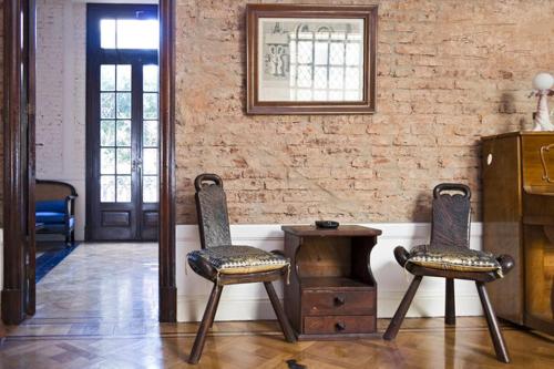 Habitación con 2 sillas, mesa y pared de ladrillo en LOFT ALMAGRO en Buenos Aires