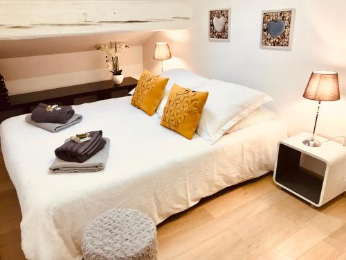 カンヌにあるLe Riviera Duplex Cannes Mer Plage Palais Festivalsのベッドルーム(白いベッド、黄色い枕、テレビ付)