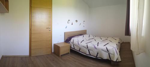 1 dormitorio con 1 cama y suelo de madera en Apartmani Luna, en Novalja