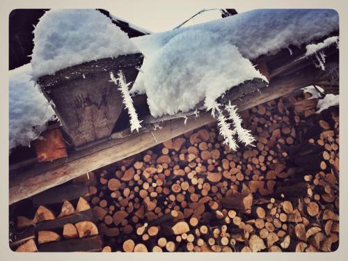 a roof covered in snow on a pile of wood at Eco Travel in Suceava