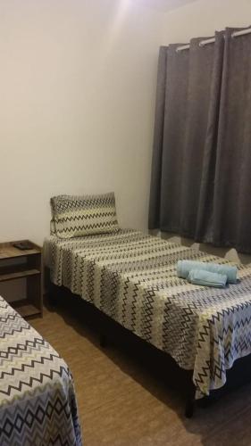 a bedroom with two beds and a window at Pousada Sarapui in Sarapuí