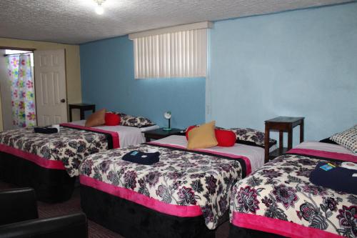 a room with three beds in a room at hotel kasa kamelot 2 in Quetzaltenango