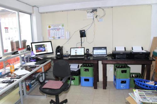 an office with a desk with three computers on it at hotel kasa kamelot 2 in Quetzaltenango