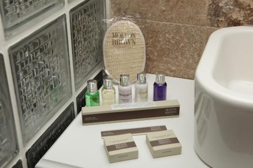 a bathroom with a sink and a toilet and some bottles at Alaçatı Çınar Boutique Hotel in Alaçatı