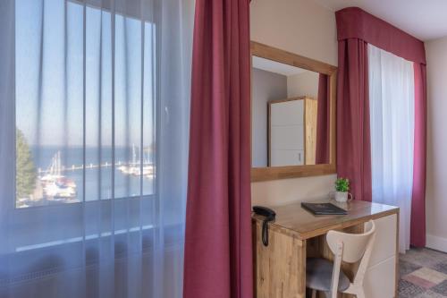 a room with a desk with a mirror and a window at Marina Pallatium Premium Floor in Kamień Pomorski