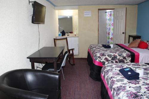 a hotel room with a desk and a bed and a table at hotel kasa kamelot 2 in Quetzaltenango