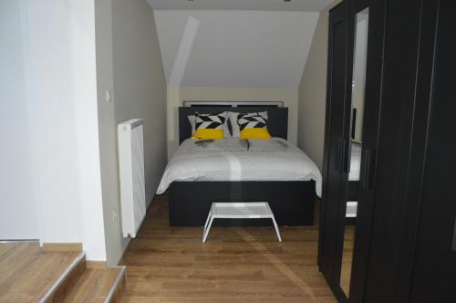 a bedroom with a bed with yellow pillows at Chez Vivi in Ans