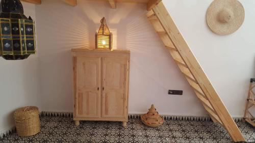 a room with a wooden cabinet with a light on it at Art studio au bord de la mer in El Jadida
