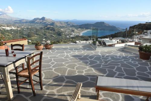 a patio with a table and chairs and the ocean at Art and Nature Apartment in Sellía