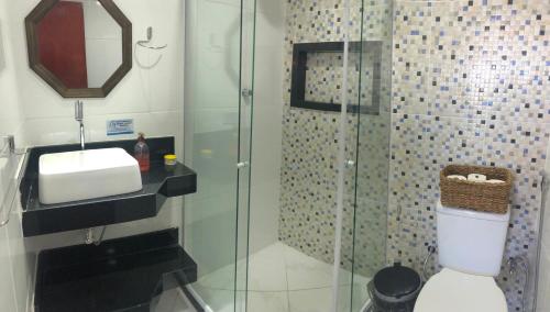 a bathroom with a shower with a toilet and a sink at Canto da Praia Suítes in Arraial do Cabo