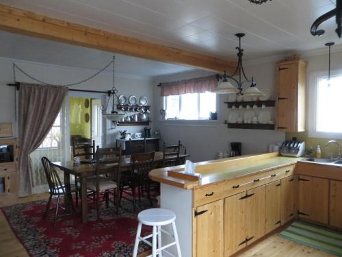 a kitchen with a table and a dining room at Gîte la Marée in Portneuf Sur Mer