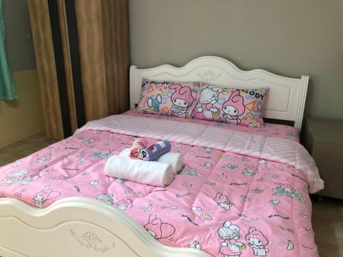 a bed with a hello kitty doll laying on it at Pani House Hatyai 1 in Hat Yai