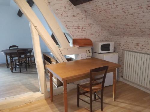 een eetkamer met een houten tafel en stoelen bij Anim'O Perch' & Gîtes (AOPEG) in Mézières-au-Perche