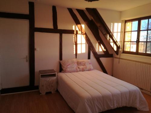 1 dormitorio con 1 cama grande en una habitación con ventanas en Anim'O Perch' & Gîtes (AOPEG), en Mézières-au-Perche