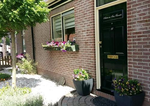 une maison avec deux boîtes de fleurs sur la porte dans l'établissement Op de Bult, à Rasquert