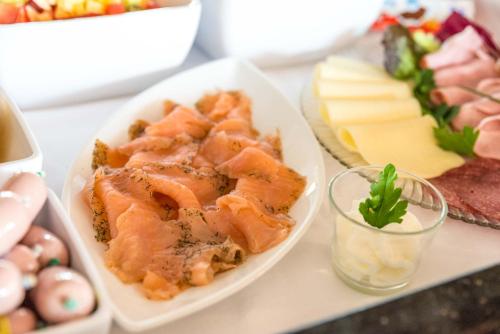 a plate of food on a table with cheese at Jauch's Löwen Hotel-Restaurant in Neuershausen