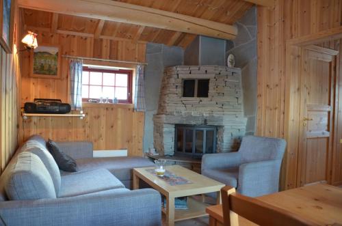 a living room with a couch and a fireplace at Northern gate Besseggen - Cottage no 17 in Besseggen Fjellpark Maurvangen in Maurvangen