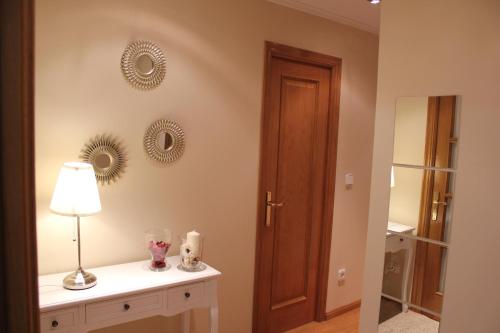 a room with a table with a lamp and mirrors on the wall at El Collado 17 in Soria