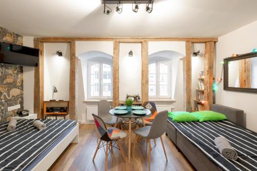 ヴロツワフにあるVintage House Rynek - StayinWroclawのベッド2台、テーブル、椅子が備わる客室です。
