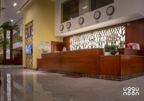 a lobby with a reception desk and clocks on the wall at Noon Hotel Suites in Al Khafji