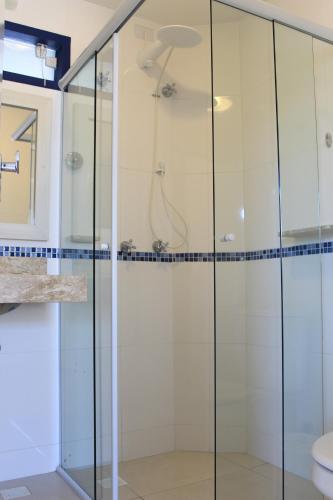 a shower with glass doors in a bathroom at Pousada Don Diego in Ubatuba