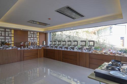 a kitchen with wooden cabinets and a large window at Mountain Glory Forest Resort in Pokhara