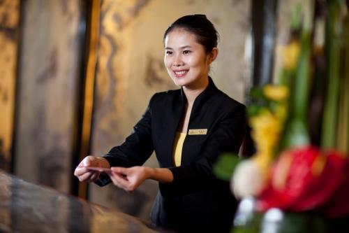 a woman is sitting at a table with her hand out at Your World International Conference Centre Hotel in Yiwu