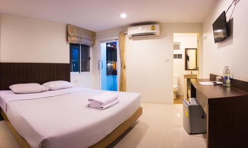 una camera con letto e un bagno con lavandino di Sunshine Hostel a Hua Hin