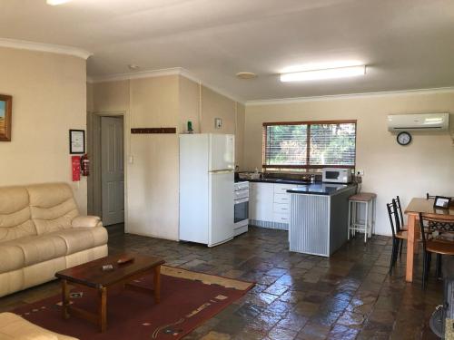 a living room with a couch and a kitchen at Country Cottages of Bridgetown in Bridgetown