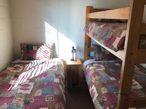a bedroom with two bunk beds and a table at Country Cottages of Bridgetown in Bridgetown