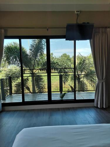 a bedroom with a bed and a window with a view at Sleep Soundly By The Sea in Trat
