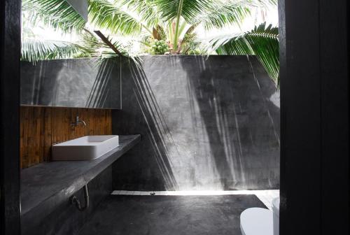 een badkamer met een wastafel en een palmboom bij Coconutnoom Ko Phangan in Thongsala
